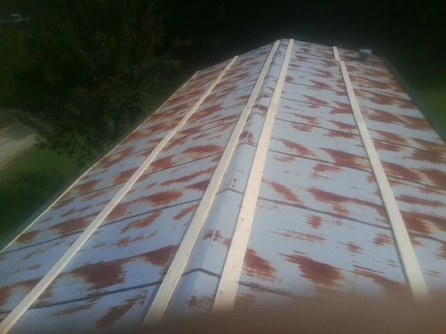 Rusted metal roof panels with new wood purlins before replacement — Storm Damage Roof Repair in Tupelo by Roofing Brothers