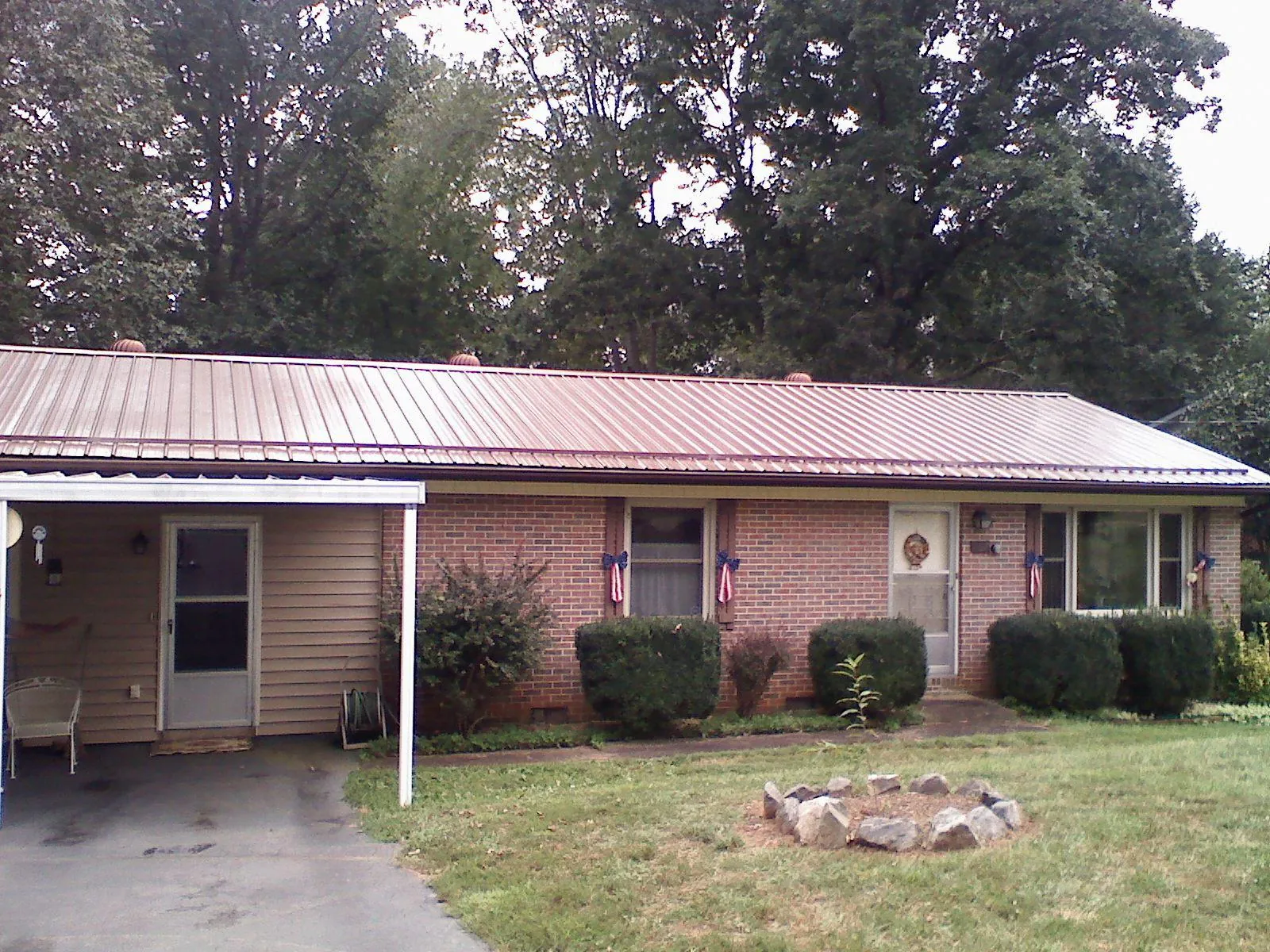 Bronze metal roof and carport on a brick ranch home — Roof Repair work by our crew in Tupelo